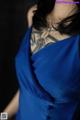 A woman in a blue dress with a tattoo on her back.