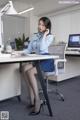 A woman sitting at a desk talking on a phone.