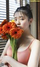 A woman holding a bunch of orange flowers in her hand.