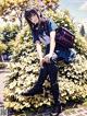 A girl sitting on top of a bush with a backpack.