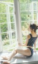 A woman sitting on a window sill looking out the window.